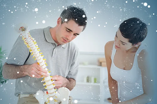 Vida Chiropractic - Chiropractor Looking at Spine Model